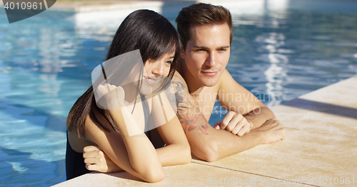 Image of Diverse good looking couple stand in swimming pool