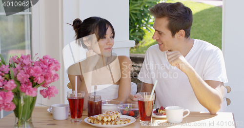 Image of Attractive couple enjoying breakfast outdoors