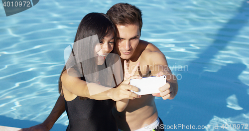 Image of Beautiful woman in black swim suit takes photo