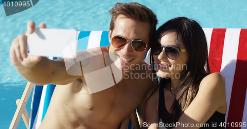Image of Smiling young couple taking a vacation selfie