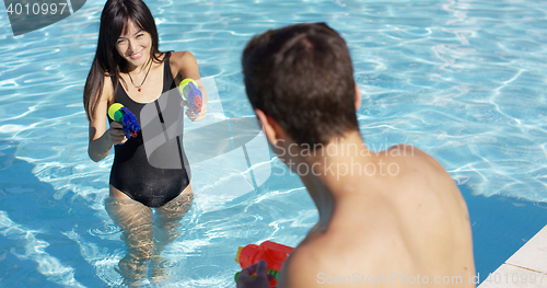 Image of Adults shooting shooting water guns at each other