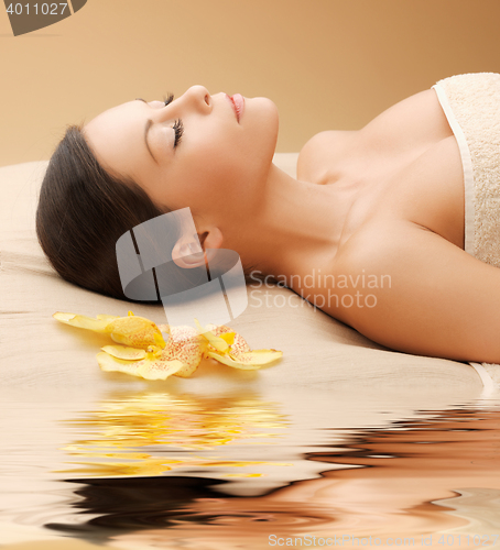 Image of woman in spa salon lying on the massage desk