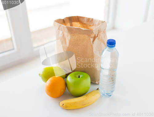 Image of basket of fresh ripe fruits and water at kitchen