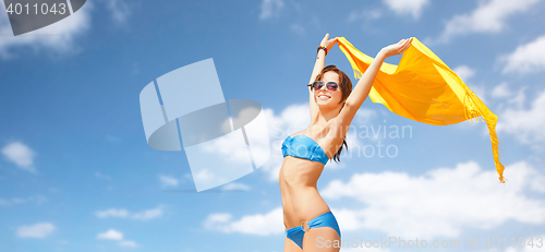 Image of woman in bikini and sunglasses over blue sky