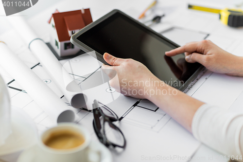 Image of close up of hand with blueprint and tablet pc