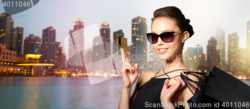 Image of happy woman with credit card and shopping bags