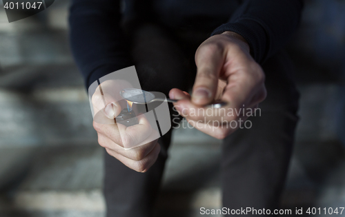 Image of close up of addict preparing crack cocaine drug