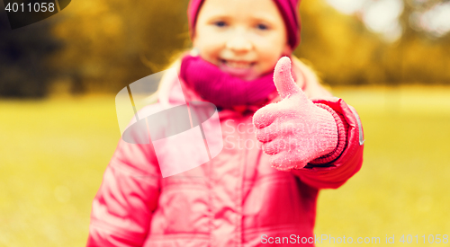 Image of happy girl showing thumbs up outdoors
