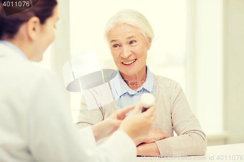 Image of doctor with medicine and senior woman at hospital