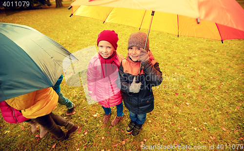 Image of happy children with umbrella in autumn park