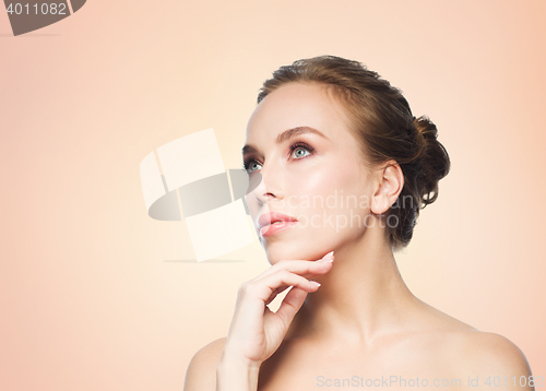 Image of beautiful young woman touching her face