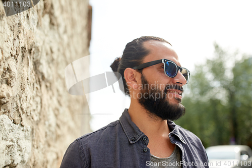 Image of happy smiling man with beard on city street