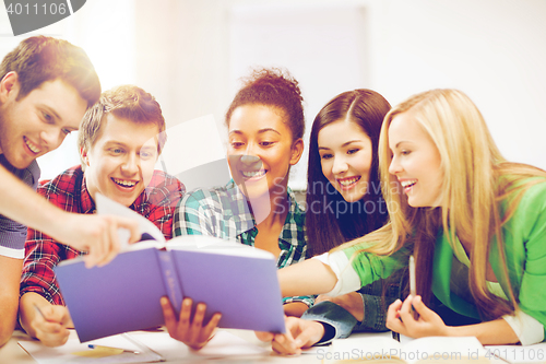 Image of students reading book at school