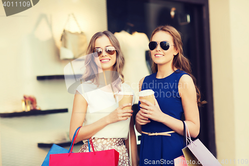 Image of young women with shopping bags and coffee at shop