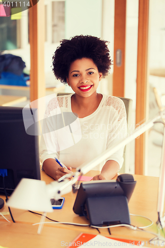 Image of businesswoman with computer and phone at office