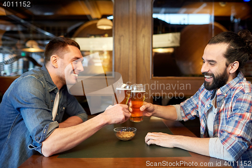 Image of happy male friends drinking beer at bar or pub