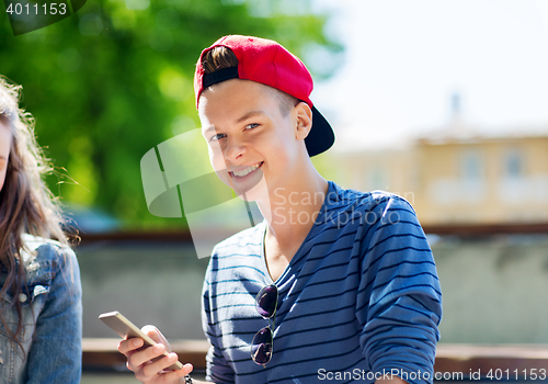 Image of happy teenage boy with smartphone outdoors
