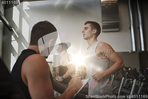 Image of men exercising on treadmill in gym