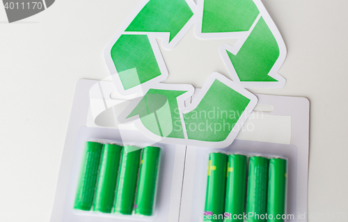 Image of close up of batteries and green recycling symbol