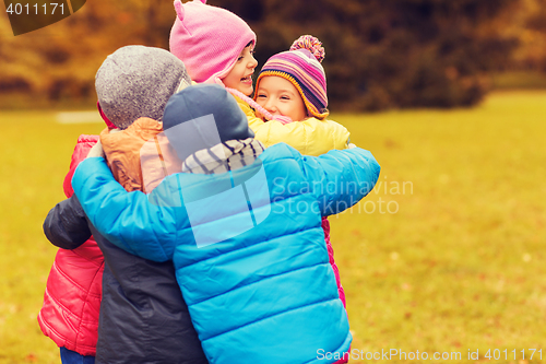 Image of group of happy children hugging in autumn park