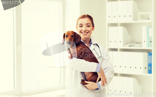 Image of happy doctor with dog at vet clinic