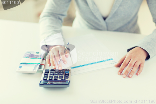 Image of close up of hands counting money with calculator