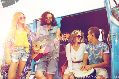 Image of happy hippie friends playing music over minivan