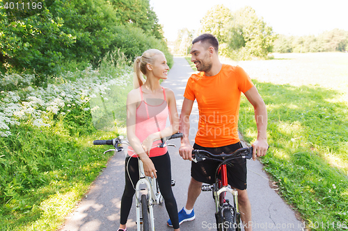 Image of happy couple riding bicycle outdoors