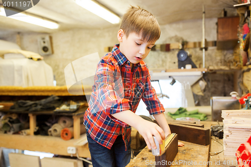 Image of happy little boy with plank and ruler at workshop