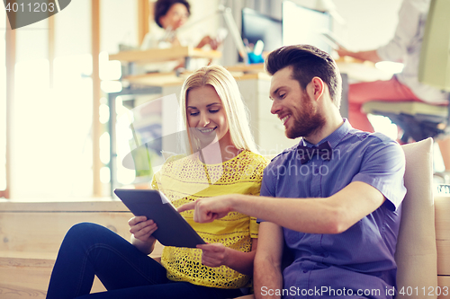 Image of happy creative team with tablet pc in office