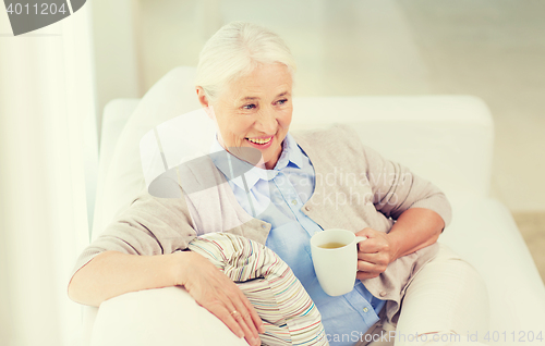 Image of happy senior woman with cup of tea at home