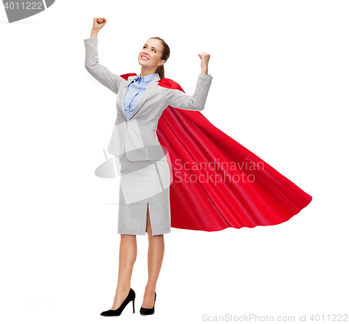 Image of young smiling businesswoman in red superhero cape