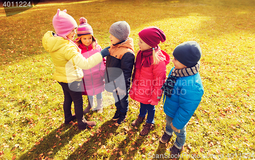 Image of kids in autumn park counting and choosing leader