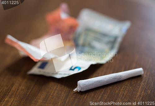 Image of close up of marijuana joint and money