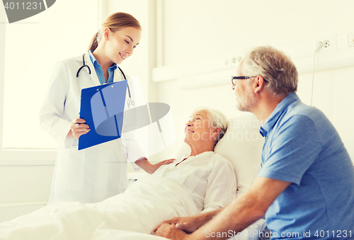 Image of senior woman and doctor with clipboard at hospital