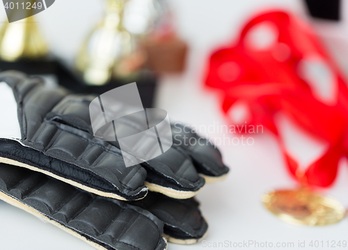 Image of close up of football, gloves, cups and medals