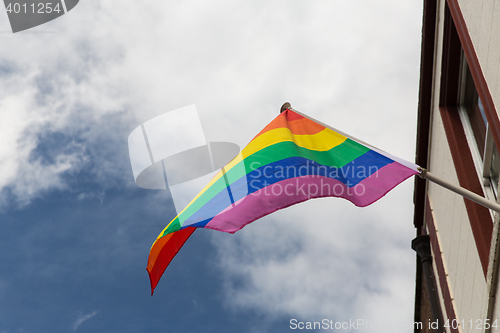 Image of close up of rainbow gay pride flag waving on building