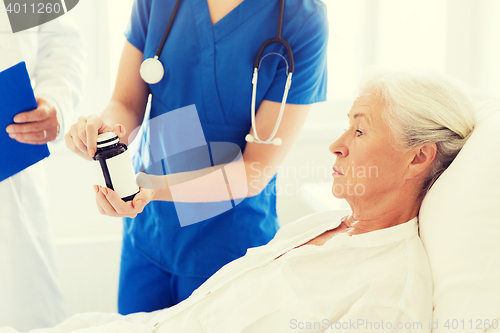 Image of doctor giving medicine to senior woman at hospital