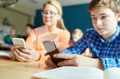 Image of high school students with smartphones texting