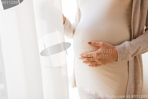 Image of close up of pregnant woman belly and hands