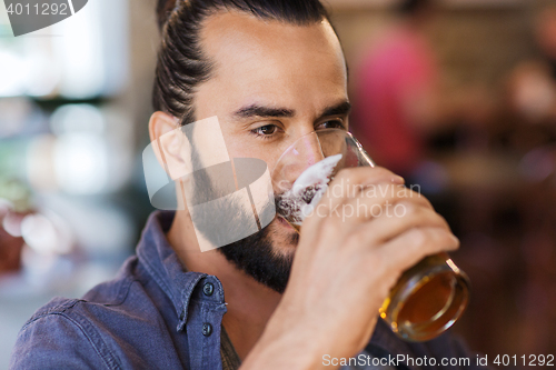 Image of happy man drinking beer at bar or pub