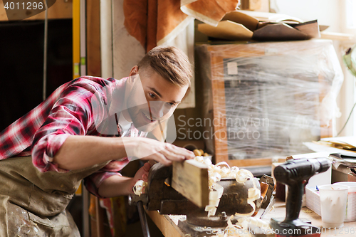 Image of carpenter working with wood plank at workshop