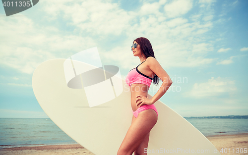 Image of smiling young woman with surfboard on beach