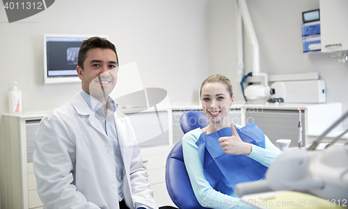 Image of happy male dentist with woman patient at clinic