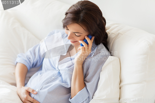 Image of happy pregnant woman calling on smartphone at home