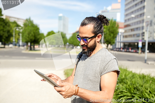 Image of man traveling with backpack and tablet pc in city