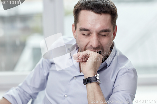 Image of yawning tired man at home or office