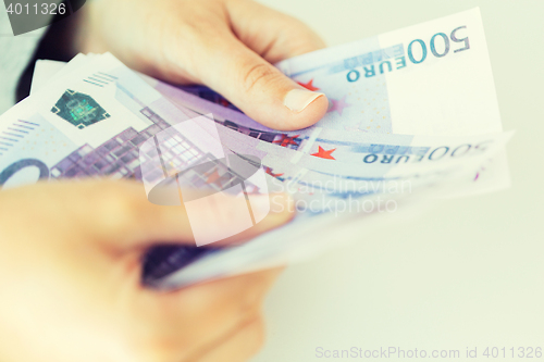 Image of close up of woman hands counting euro money