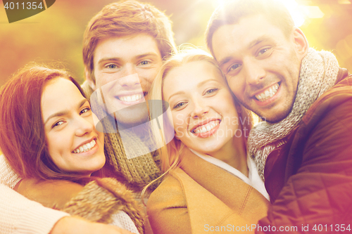 Image of group of friends having fun in autumn park