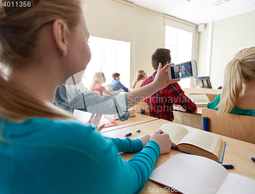 Image of student girls taking smartphone selfie at school